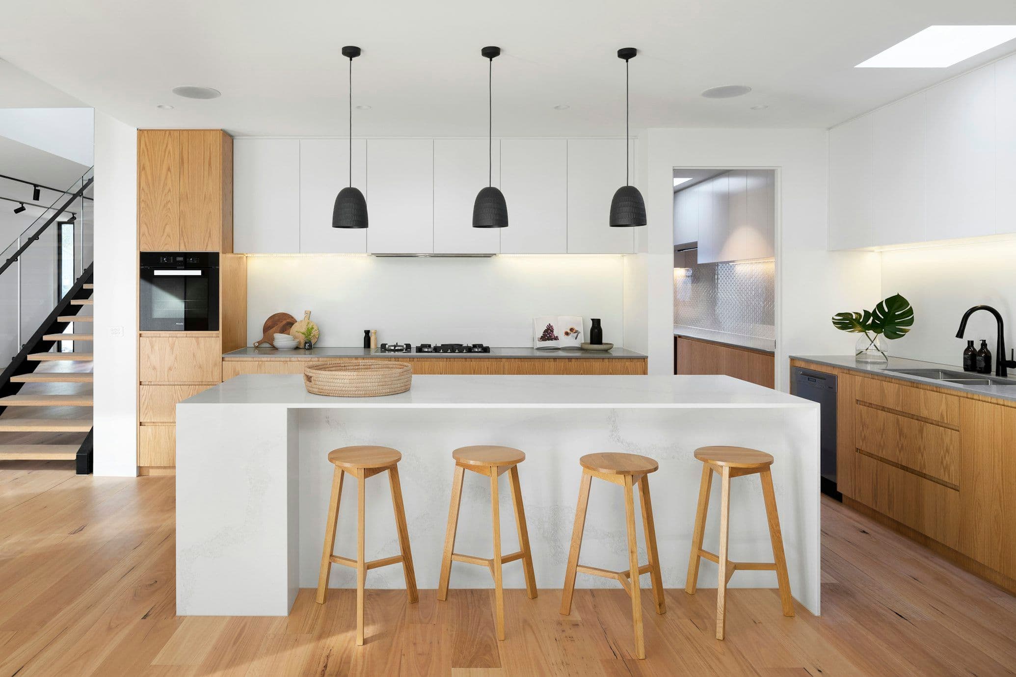 Contemporary bespoke kitchen installation with quartz waterfall island
